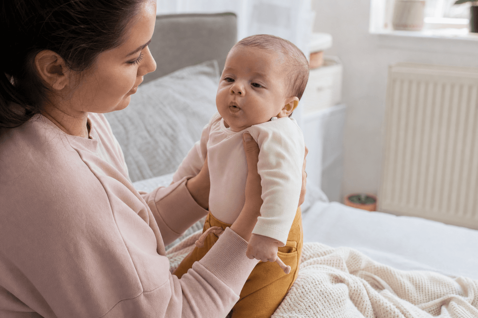 Parent holding a baby upright after feeding in a calm home, natural light, editorial lifestyle photo