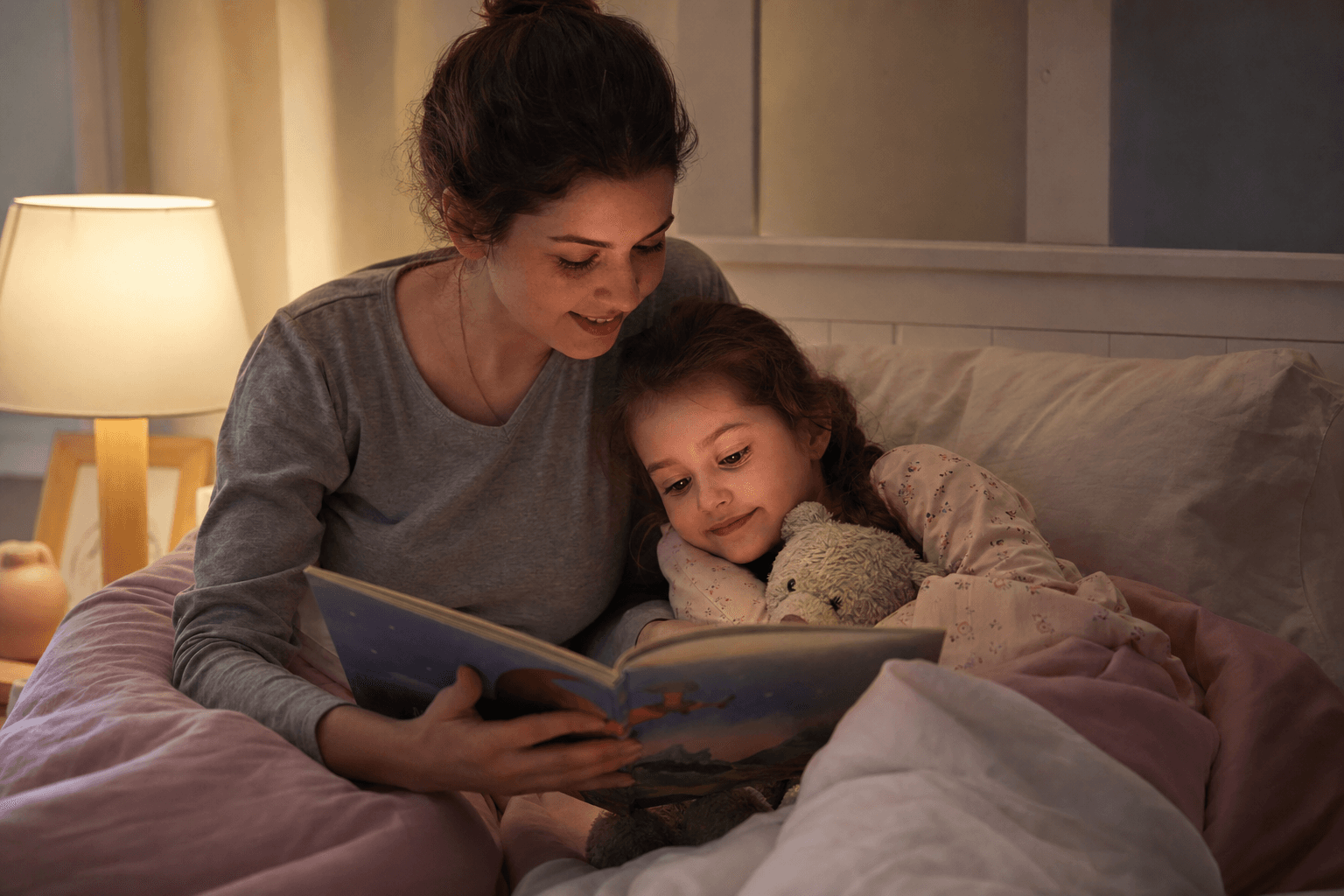 Imagine fotorealista, fara text, cu un copil mic in pijama care se joaca linistit cu o carte inainte de culcare, in lumina calda de seara